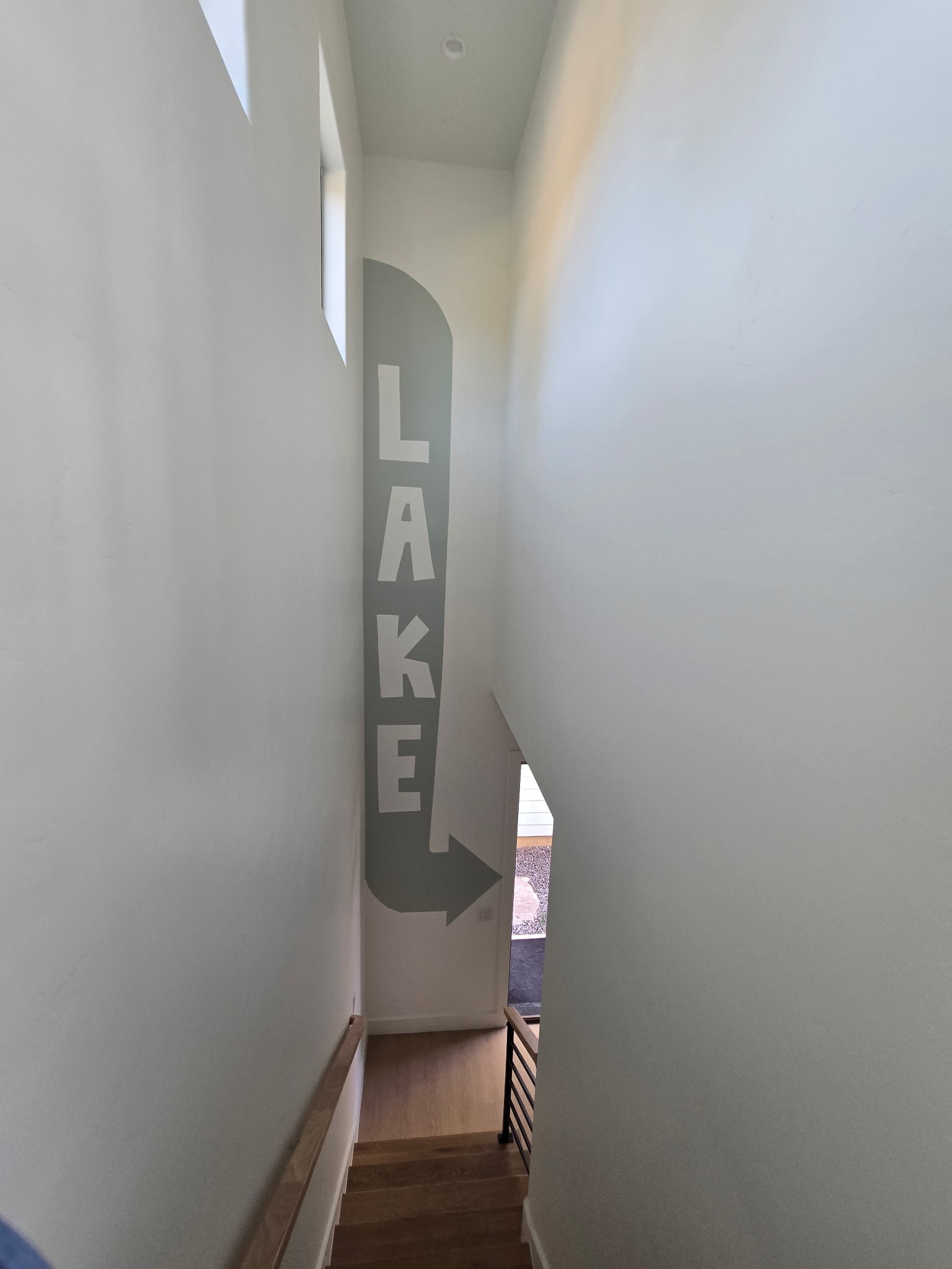 Stairwell with painted LAKE arrow sign pointing to the water